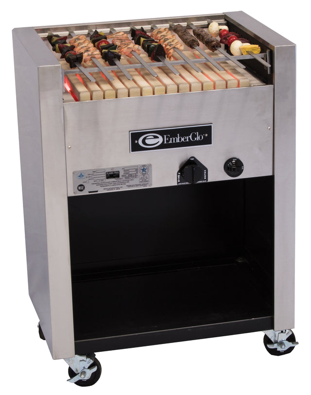 A stainless steel Kabob Charbroiler EmberGlo grill with skewers of meat and vegetables on a ceramic hearth, featuring a control knob and vents on the front, stands on four caster wheels with open storage below. Operates on natural gas.