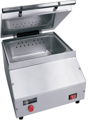 A stainless steel countertop steamer with a hinged lid open, revealing a perforated removable tray. The front panel features a red button, power switch, brand label, and angled edges. Designed for commercial use with an optional direct water hookup.