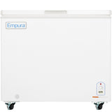 A white Empura solid lid freezer on four caster wheels features a large front panel with a small control panel and temperature display in the lower right corner. The chest freezer lid has a recessed handle along the top edge.