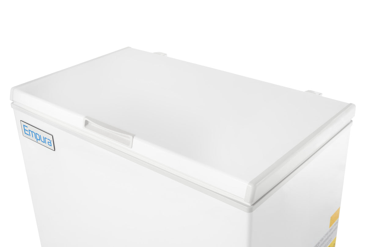 A white Empura chest freezer with a solid lid is shown at an angle against a plain white background. The freezer features a recessed handle and the Empura refrigeration logo on the top left corner of the front panel.