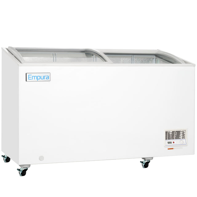 A white Empura commercial chest freezer with a sliding glass top sits on four wheels for easy mobility. This curved lid freezer features a control panel and vent near the bottom right corner, with the spacious interior visible through the glass.