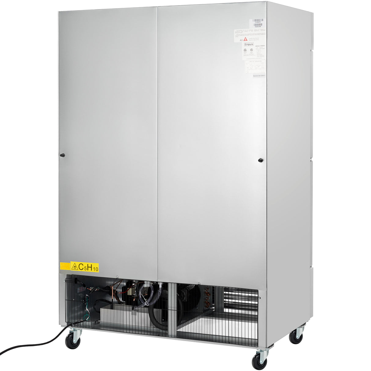 A large, stainless steel commercial freezer with double front doors, ventilation grilles at the bottom, and mechanical components partially visible behind the grille. The unit sits on four caster wheels with a power cord extending from the left side.