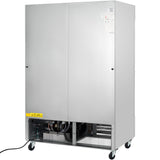 A large, stainless steel commercial freezer with double front doors, ventilation grilles at the bottom, and mechanical components partially visible behind the grille. The unit sits on four caster wheels with a power cord extending from the left side.