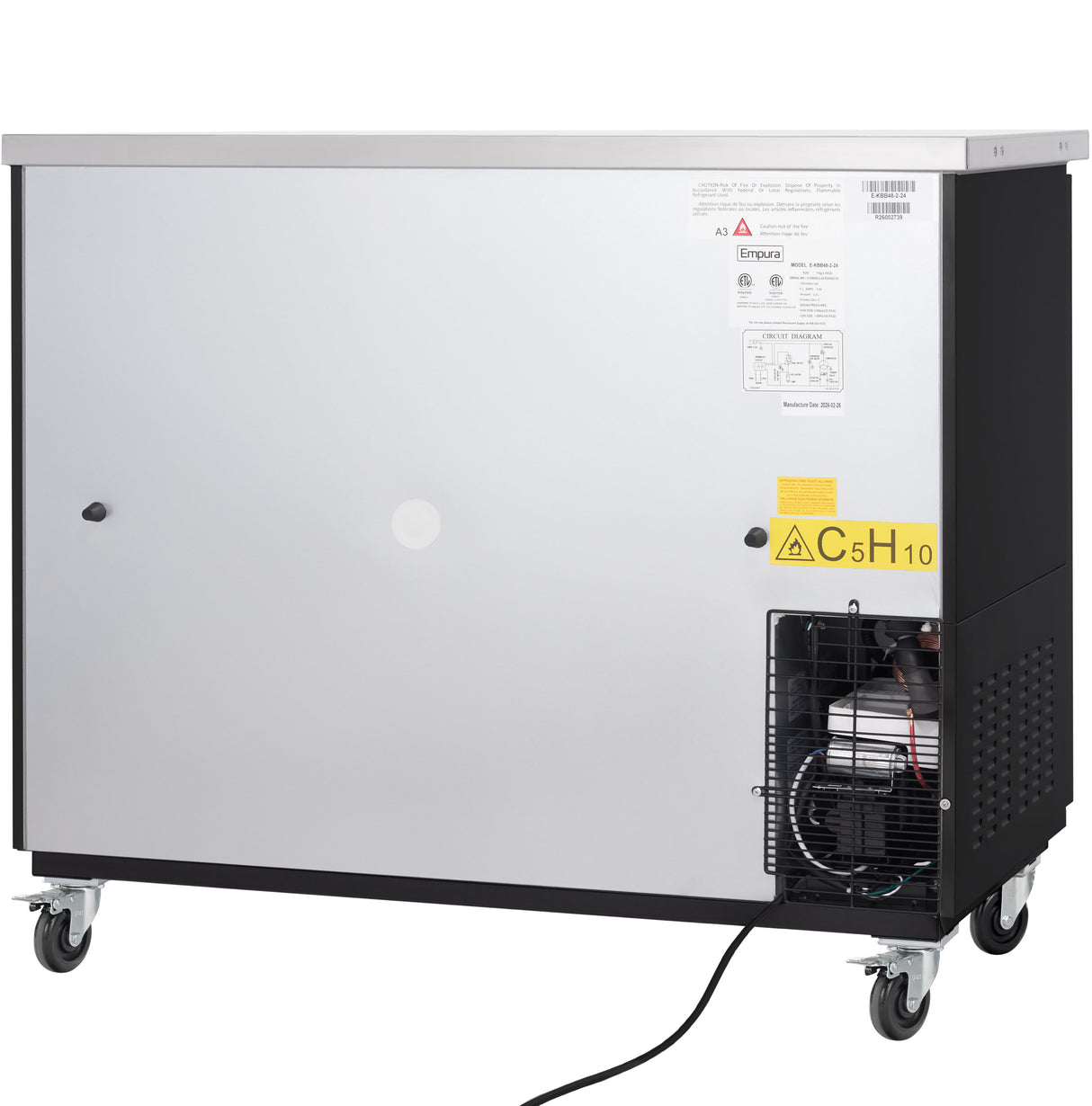 A large, stainless steel commercial machine on wheels with a vented section revealing mechanical parts at the lower right. There are warning labels, including a yellow one with C5H10 for isopentane gas. A power cord extends from the bottom.
