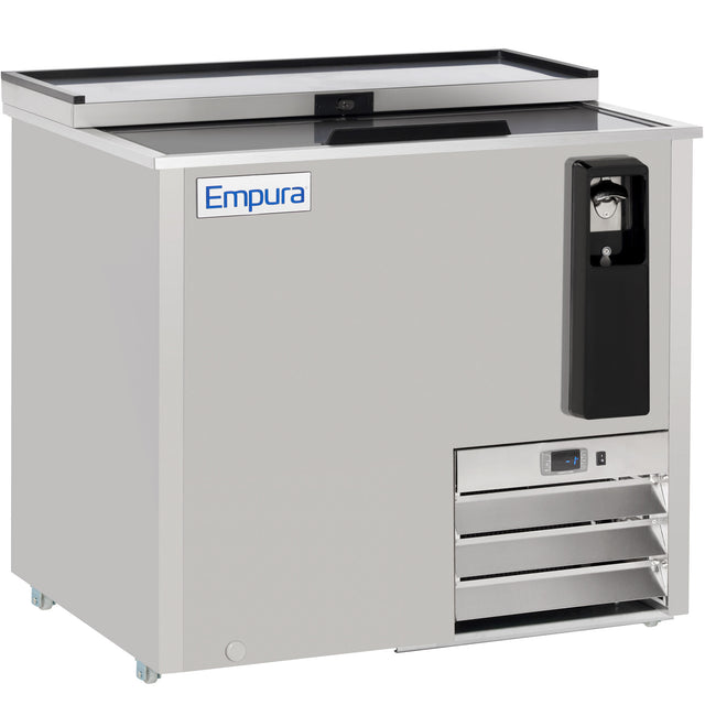 The Empura Refrigeration stainless steel bottle cooler features a sliding lid, built-in bottle opener, cap catcher, ventilation grates, and a control panel. Branded “Empura” on the front, it stands on small wheels for easy mobility.