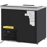 A black sliding door cooler with a flat silver top, ventilation grates at the bottom left, and several white information labels and warning stickers on the upper right. The front features a yellow caution sign with the chemical formula “C5H10.”.