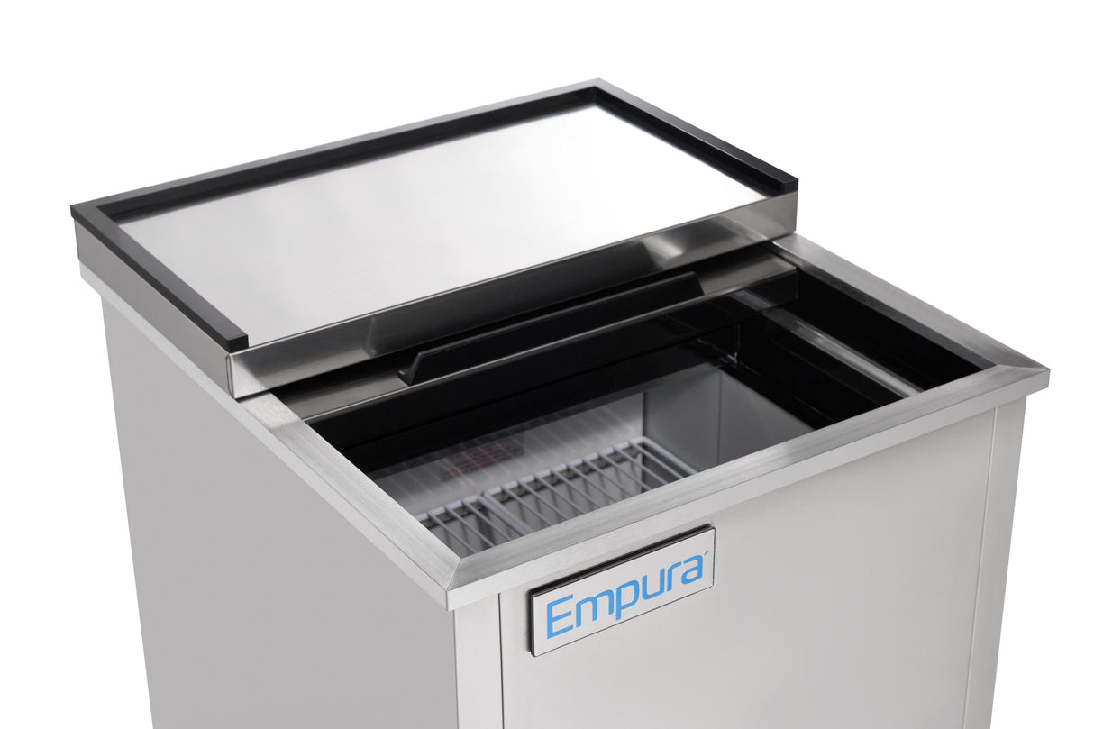 A stainless steel commercial freezer from Empura Refrigeration with a sliding lid partially open, showing empty wire racks inside. The front displays a blue and white Empura label, and the clean, spacious interior stands out.