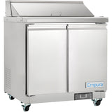 A stainless steel Empura refrigeration sandwich prep table with two doors, a raised covered prep area on top, side ventilation, and wheels for mobility. The front displays the brand name Empura on a blue and white label near the bottom right corner.
