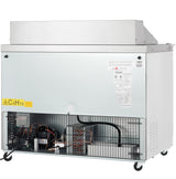 A commercial ice maker machine on wheels, by Empura Refrigeration, with a metal exterior. The lower front panel is open, revealing electrical wiring and compressor. Labels, including a yellow chemical warning for C5H10, are visible on the front.