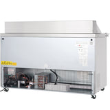 A large, silver industrial Empura refrigeration machine with an open lower panel reveals mechanical components, wires, and coils inside. The exterior is metallic with vents on the side, similar to a mega top prep table on wheels featuring warning labels and instructions.