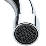 Close-up of a shiny, chrome Empura Stainless faucet spout angled downward. The rounded tip features a black, honeycomb-patterned aerator. The plain white background highlights the wall mount faucet’s polished surface.