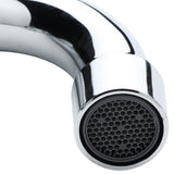 Close-up of a shiny, stainless wall mount faucet with a curved spout. The end features a round aerator showcasing a honeycomb-like grid pattern inside. The background is plain and white.