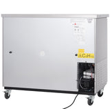 A large, rectangular, stainless steel industrial machine on four wheels, with labels and warning signs on its front panel. A vented section and visible mechanical parts are on the lower right, including a C5H10 yellow warning label.