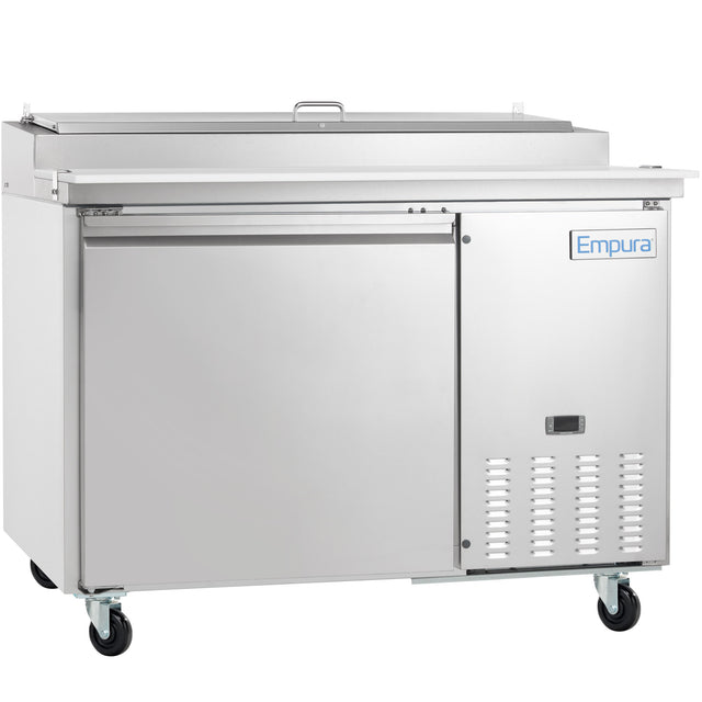 A large Empura Refrigeration stainless steel pizza prep table with a single door, top prep station with closed lid, ventilation grates at the bottom right, and four caster wheels for mobility. The Empura logo is visible on the upper right side.