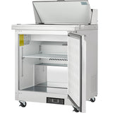 An Empura Refrigeration unit, this stainless steel refrigerated sandwich prep table on wheels features a single open door revealing a wire shelf inside. Its top section has a raised, open lid for extra storage or prep space against a plain white background.