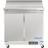 A stainless steel Empura refrigeration sandwich prep table on four black caster wheels, featuring two front doors with a horizontal handle and the Empura name in blue. The flat metal lid covers the top, ideal for use as a salad mega top prep table.