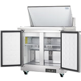 A commercial Empura refrigeration salad mega top prep table with a top lid open and two front doors wide open, revealing empty interior shelves and compartments. The unit has wheels for mobility and a control panel at the bottom front.