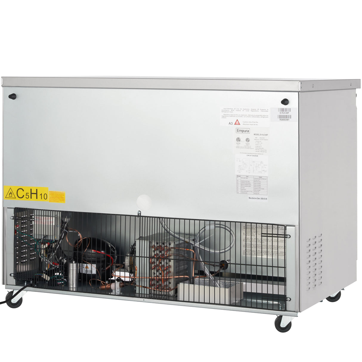 A large, metallic Empura E-KUC48F commercial freezer on wheels with an exposed lower section revealing wiring, compressor, and cooling components. The upper part is plain, featuring warning labels, technical stickers, and ventilation holes on the right side.