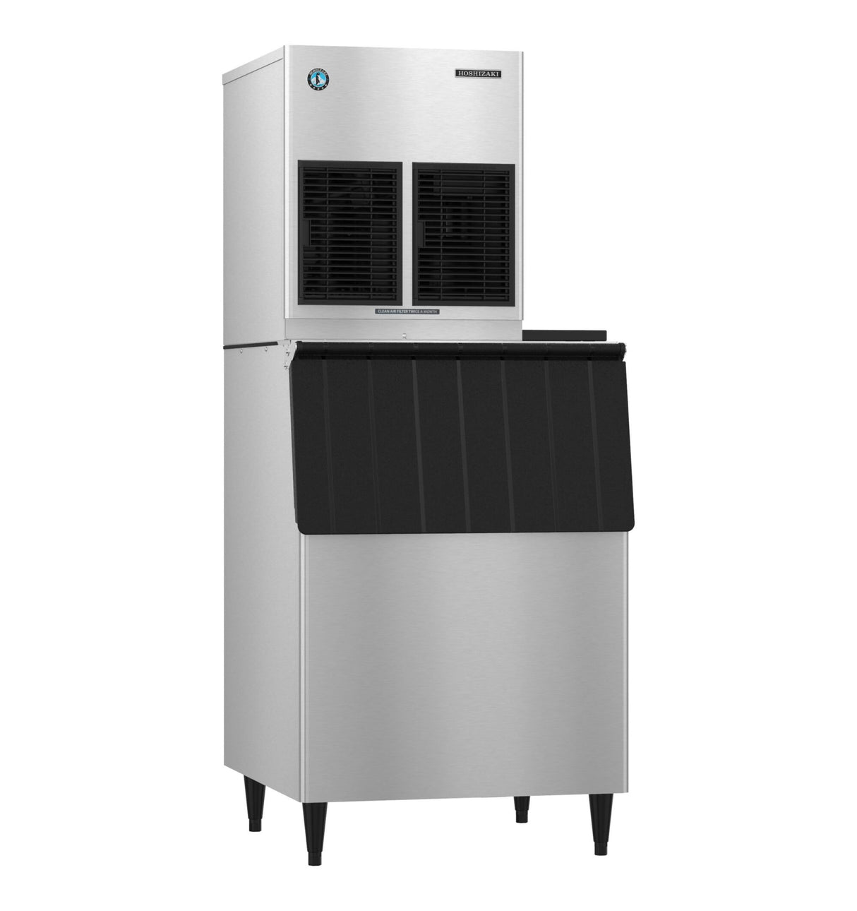 A high production ice machine and storage bin made of stainless steel with a black front panel. The top unit has two vented sections, and the lower bin features a slanted black door. The machine stands on four black legs against a white background.