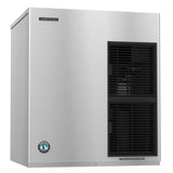 A stainless steel Hoshizaki Flake-Style Ice Maker with a brushed metal finish. It features a front vent with black horizontal slats and a rectangular brand label in the top left, plus a round logo at the bottom left corner.
