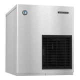 A stainless steel Hoshizaki Flake-Style Ice Maker with a smooth, boxy design. The front panel features a black vented grille on the lower right and a small circular blue logo on the upper left, with the Hoshizaki brand name at the top right.