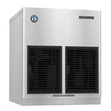A stainless steel Hoshizaki ice maker with two large black vents on the front, a round certification sticker on the upper left, and a small rectangular label on the upper right. A white label below the vents reads “CLEAN AIR FILTER TWICE A MONTH.”.