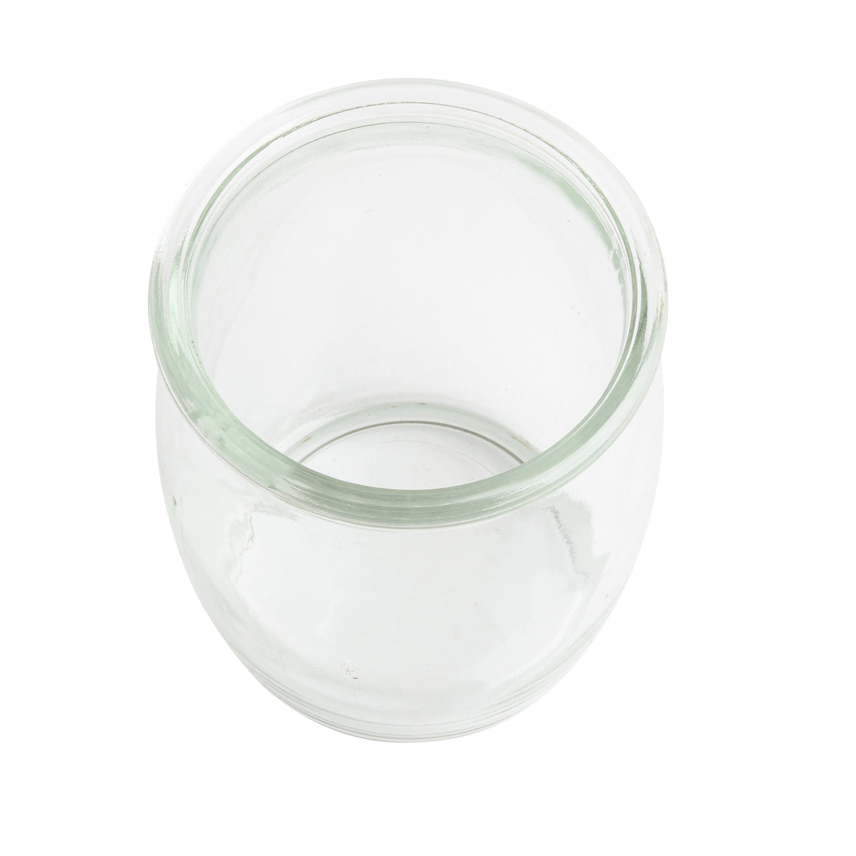 A clear, empty, round 4 oz glass jar with a wide opening is shown on a white background, viewed from above. The jar is transparent, has no lid or markings, and reflects the timeless charm of vintage style glasses.