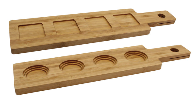 Two rectangular TableCraft FLIGHT1 bamboo flight boards with handles and end holes. One board has four square indentations, the other four circular, perfect as a wood paddle flight for serving cups, bowls, or snacks. Smooth with visible bamboo grain.