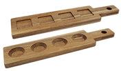 Two rectangular acacia wood paddle flight boards with handles and holes for hanging. The top has four square depressions, the bottom four round, perfect for holding glasses or cups. Smooth finish—ideal for cash & carry.