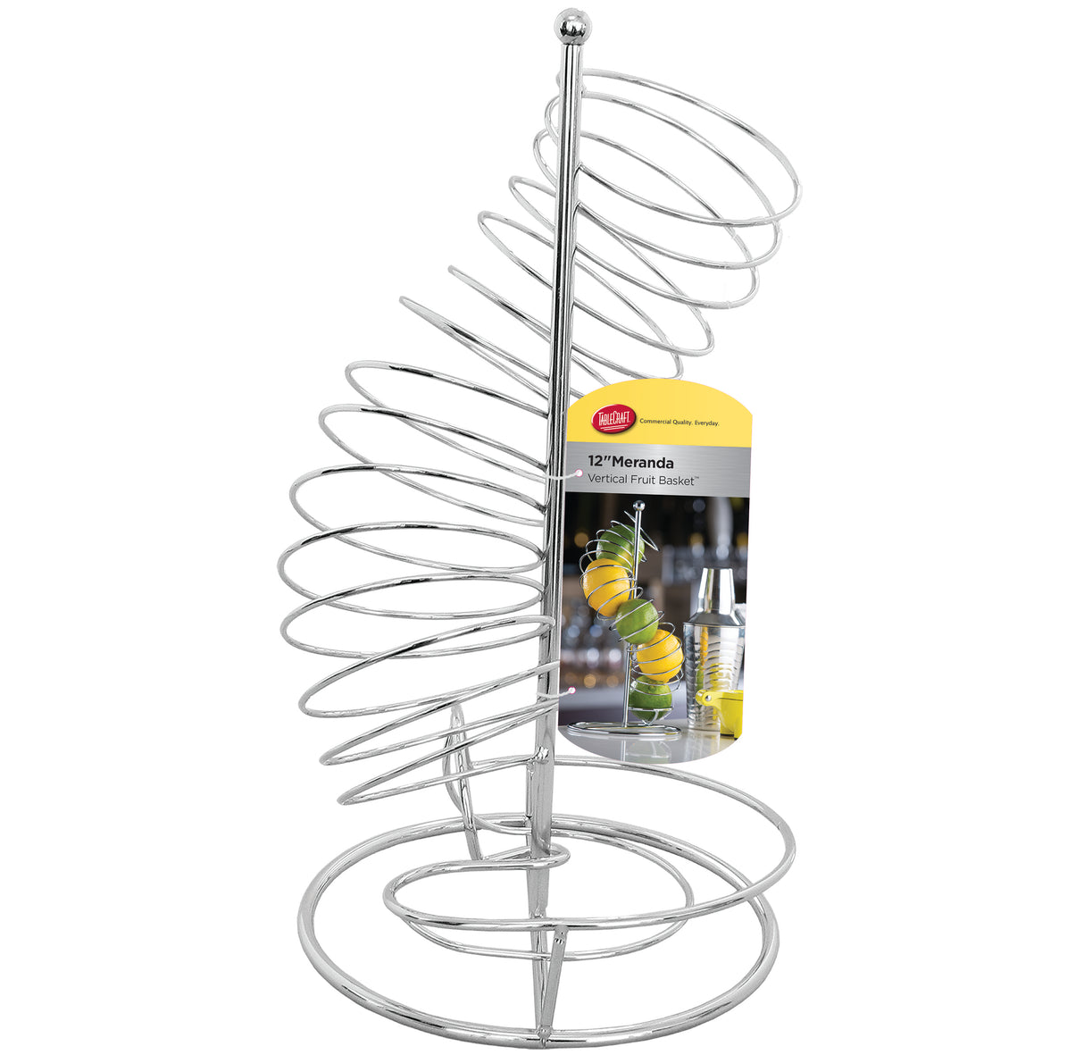 A silver, spiral-shaped chrome plated fruit basket stands upright with a round base. A TableCraft product tag shows it filled with lemons and limes. The spiraled design lets fruits roll down from top to bottom for easy access.
