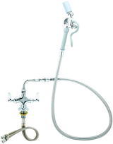 A commercial pantry deck mount faucet with a flexible metal hose, dual handle valves for hot and cold water, and a spray nozzle with a white plastic handle. Hoses extend from the base for water connection. The industrial design is highly functional.