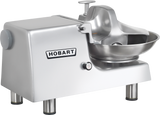 A Hobart Food Cutter with a shiny metal body, round stainless steel bowl, and protective shield. The machine stands on four sturdy legs with a large knob on the left side, and the Hobart brand name is displayed prominently on the front.