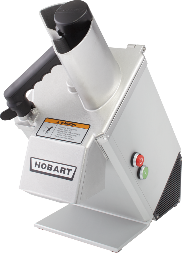 A commercial stainless steel Food Processor with a silver body, labeled HOBART on the front. It features a cylindrical feed chute for continuous feed, a black pusher handle, warning label, and green and red power buttons on the sturdy base.