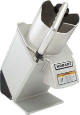 A commercial Hobart food processor with a stainless steel finish, vertical handle, large continuous feed chute, and warning label on the front. The machine is tilted on its stand, showing vents and minimal controls against a plain white background.