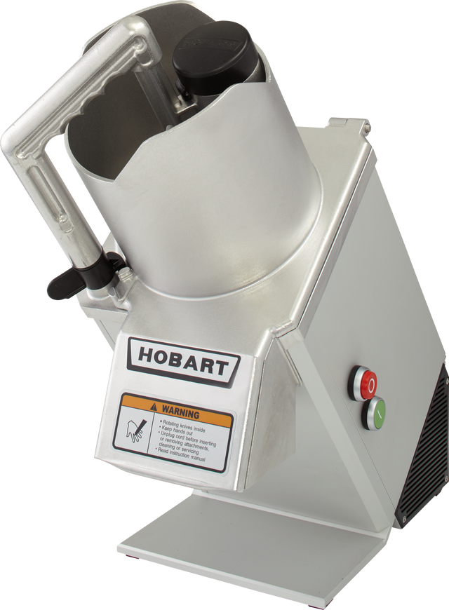 A stainless steel Hobart commercial food processor with a black handle, safety guard, and continuous feed chute. The front features a yellow warning label, while two round buttons—one red and one green—are on the side for operation.