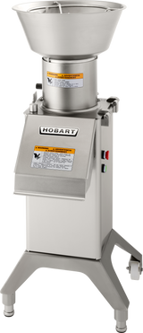 A stainless steel Hobart FP300I continuous-feed food processor with a large bowl and lid, warning labels, side control panel with red and green buttons, and four sturdy legs, designed for commercial kitchen use.
