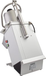 A commercial Hobart food processor with a tilted stainless steel body, large cylindrical feed tube for continuous feed, pusher handle on top, and red and green control buttons. The machine has a label on the front and stands on a metal base.