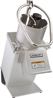 A Hobart commercial Food Processor with a metal body, circular continuous feed chute, and pusher handle. A warning label is visible on the front. This heavy-duty machine sits on a flat base, ideal for demanding kitchen tasks.