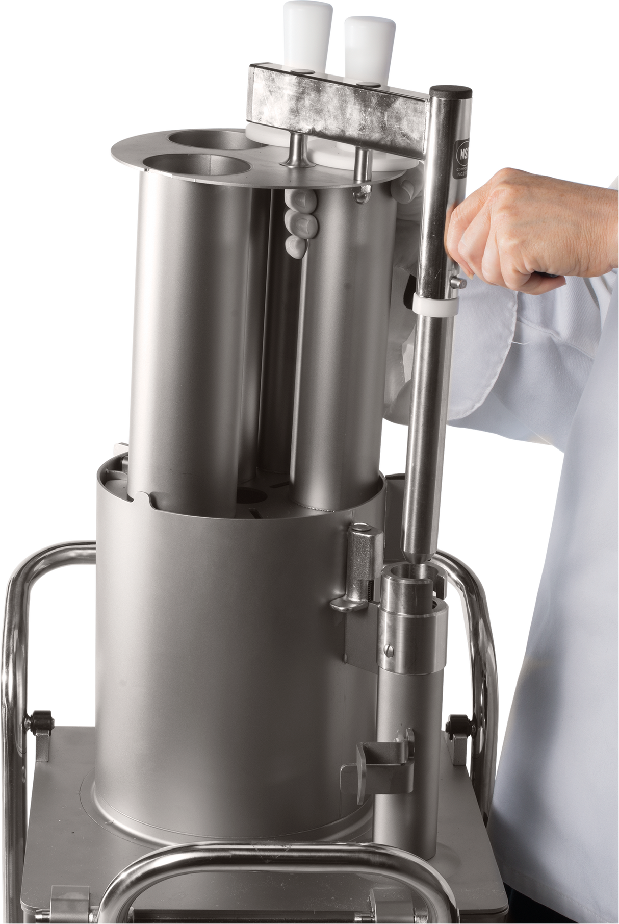 A person in a white lab coat operates a Hobart FP400I Continuous-Feed Food Processor with cylindrical components and two white handles, mounted on a metal cart. The person’s hand is gripping a vertical lever on the right side of the device.