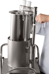 A person in a white lab coat operates a Hobart FP400I Continuous-Feed Food Processor with cylindrical components and two white handles, mounted on a metal cart. The person’s hand is gripping a vertical lever on the right side of the device.