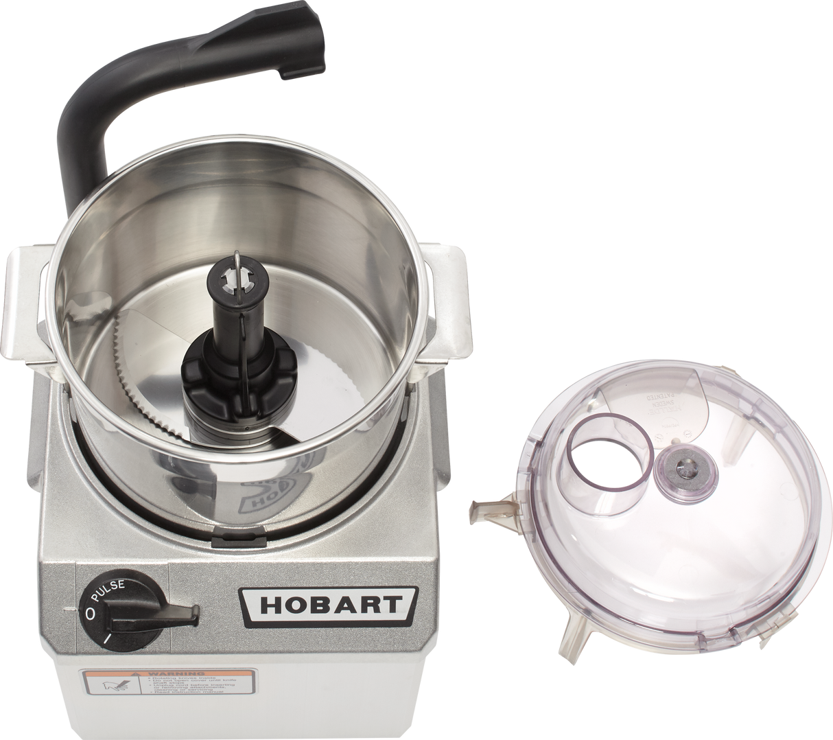 A top view of a silver Hobart food processor with an open stainless steel 4 qt bowl, revealing a sharp S-blade. The clear plastic lid with feed tube and cap rests to the side, while the control knob is set to off/pulse.