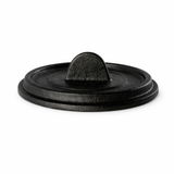 A round, black FortaLite Mini Cassolette lid with a flat top and small, arched handle in the center. The slightly textured cast aluminum surface is photographed on a white background, highlighting its sturdy, minimalist design.