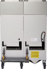 Rear view of a large, industrial high efficiency fryer on four black caster wheels, featuring pipes, shutoff valves, warning labels, and connection points near the bottom; one black cable extends from the right side.