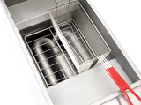 A close-up view of a PowerFry5 Fryer, a high efficiency commercial gas fryer, shows its stainless steel basket with red handles above the heating element and grill inside the clean, empty unit against a plain white background.