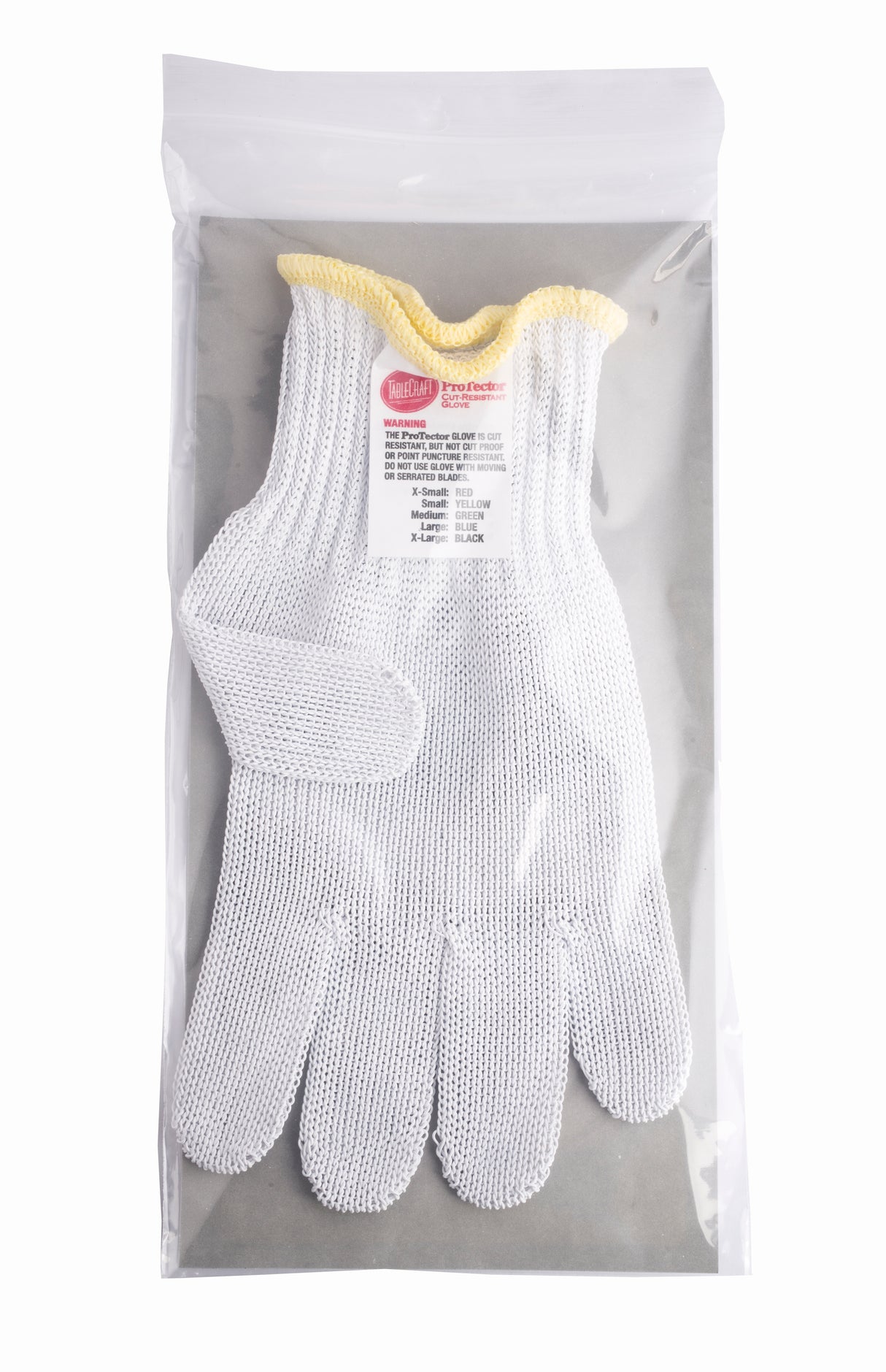 A white TableCraft stainless steel glove with a yellow-trimmed wrist is packaged flat inside a clear resealable plastic bag. A white label with red and black text is visible on the front of this cut resistant glove.