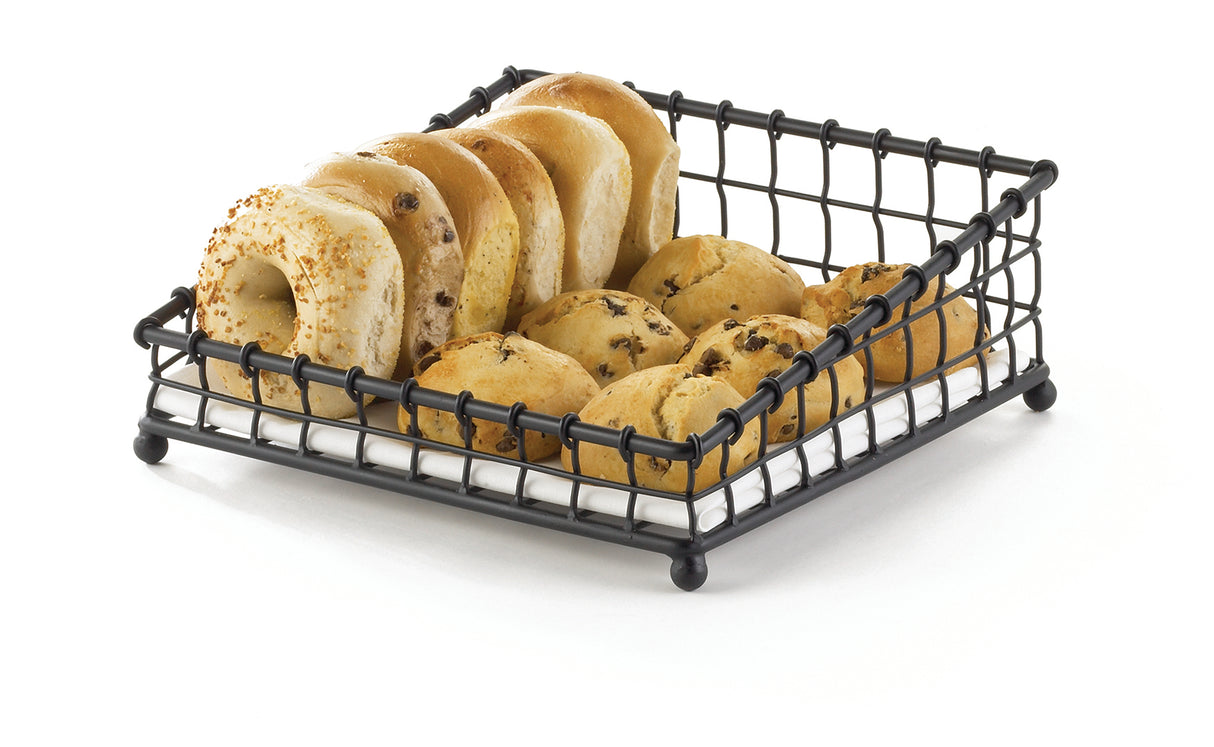 A black powder coated metal TableCraft Products Grand Master Collection Basket holds four bagels and six chocolate chip muffins, arranged neatly in two rows, on a white surface with a simple, clean background.