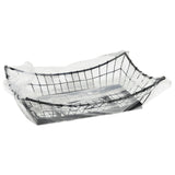 A TableCraft GM1608 rectangular black metal basket sits on a white background, partially wrapped in a transparent plastic bag. The bag drapes loosely, leaving the Grand Master Collection basket’s wire structure clearly visible.