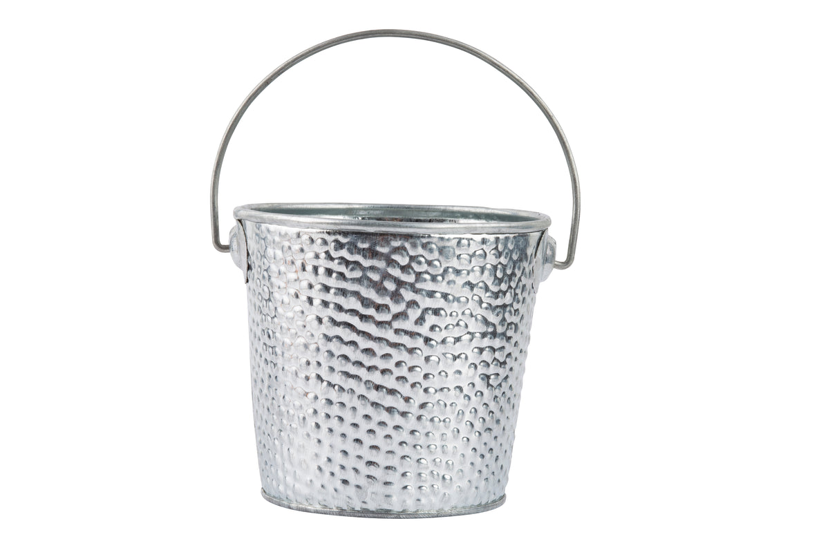 A small, silver galvanized pail with a hammered texture and a thin, curved handle attached on both sides. The steel pail is empty and isolated on a white background, with its handle raised halfway above the rim.