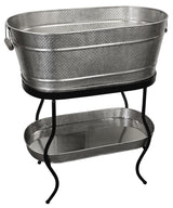 From the Brickhouse Collection by TableCraft Products, this Beverage Tub Set features a large, oval hammered metal tub with handles on a sturdy black stand. Below, a matching textured tray sits on the lower shelf for added style and function.