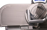 Close-up of a Chefmate Series 12 inch slicer, with a ribbed sliding tray on the left and an angled food holder on the right. The compact slicer features clean, industrial metallic surfaces and visible mechanical parts.